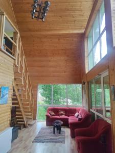 a living room with red couches and a staircase at Cabana 7 izvoare in Remeţi