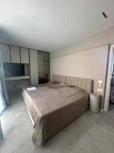a bedroom with a large bed and a flat screen tv at Villa RRE Green Coast in Palasë +28 photos