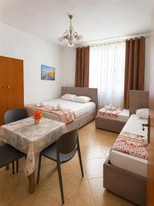 a room with two beds and a table and chairs at Prime rooms in Durrës
