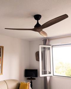 a ceiling fan in a living room with a window at Alta Suarella in Saint-Florent +10 photos