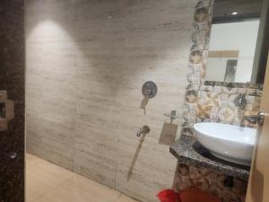 a bathroom with a sink and a mirror at Hotel Metro Palace L&B in Panvel