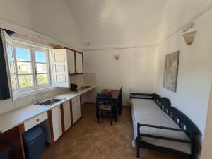 a small kitchen with a bed and a sink at Leonidas Apartments in Kamari