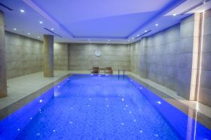 a swimming pool in a building with a blue ceiling at Marion Hotel Erbil in Erbil