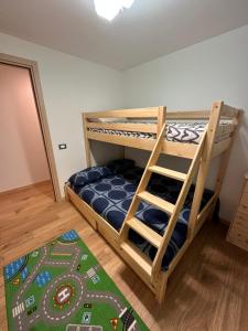 a bedroom with two bunk beds and a rug at SnowLodge Valmalenco in Caspoggio