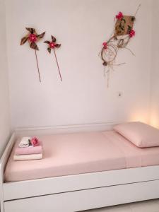 a bed with three flower decorations on the wall at Dinas house ofrinio in Ofrínion