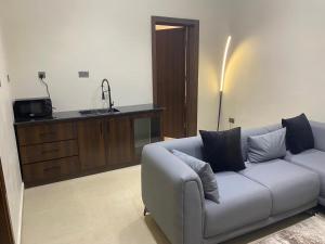 a living room with a couch and a kitchen at Teestone Hotels and Apartment Ikeja in Lagos