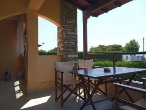 a wooden table and chairs on a patio at Studios Tripiti in Nea Roda