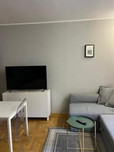 a living room with a couch and a flat screen tv at Main Square Sławkowska Apartment in Krakow