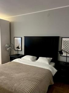 a bedroom with a large bed with a black headboard at Main Square Sławkowska Apartment in Krakow