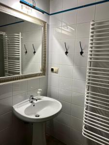 a white bathroom with a sink and a mirror at Main Square Sławkowska Apartment in Krakow