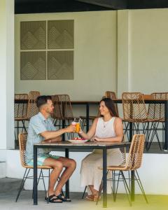 a man and a woman sitting at a table at Palm Springs Bali Dive Resort in Tulamben