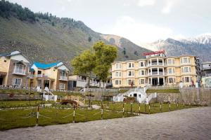 a group of buildings in front of a mountain at Falettis Grand Hotel Naran in Naran