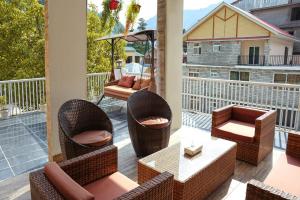 a patio with chairs and tables on a balcony at Falettis Grand Hotel Naran in Naran