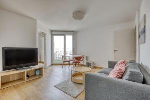 a living room with a couch and a flat screen tv at Le Palacio in Saint-Denis