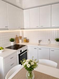 a kitchen with white cabinets and a vase of flowers on a table at Dinas house ofrinio in Ofrínion
