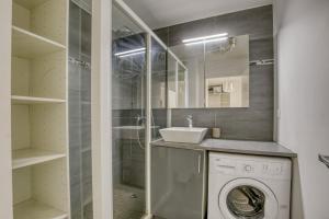 a bathroom with a washing machine and a sink at Le Palacio in Saint-Denis +20 photos