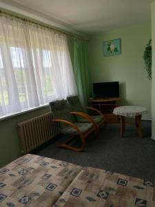 a room with a chair and a table and window at Pension Doris in Velká Hleďsebe +14 photos