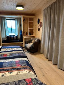 a bedroom with a bed and a chair and a window at Kulturgården Bjerkem in Steinkjer