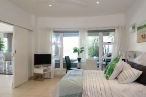 a bedroom with a bed and a living room with a television at San Maarten 12 in Sheffield Beach