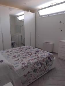a bedroom with a bed with a floral bedspread at APPARTAMENTO in seminterrato PALMAROLA in Sabaudia