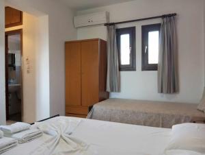a hotel room with two beds and a window at Studios Tripiti in Nea Roda