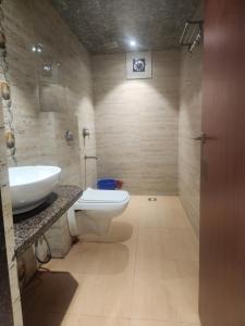 a bathroom with a white toilet and a sink at Hotel Metro Palace L&B in Panvel +13 photos