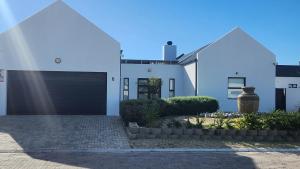 a white house with a black garage door at Ocean Whisper in Velddrif