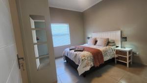 a small bedroom with a bed and a window at Ocean Whisper in Velddrif +15 photos