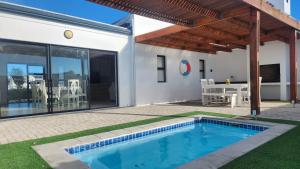 a swimming pool in the backyard of a house at Ocean Whisper in Velddrif