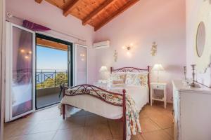 a bedroom with a bed and a balcony at Archontiko Loukis in Pentátion +92 photos