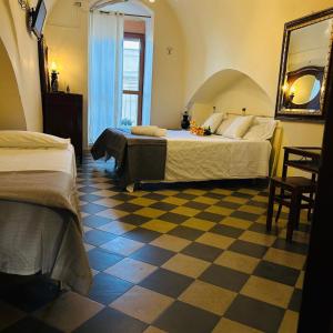 a bedroom with two beds and a checkered floor at Santa Cesarea Sassi in Matera