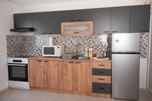 a kitchen with wooden cabinets and a white refrigerator at Apartman Sofija Palić in Palić