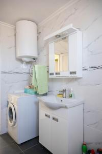 a white bathroom with a washing machine and a sink at Apartman Sofija Palić in Palić +30 photos