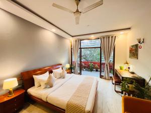 a bedroom with a bed and a desk and a window at Grove Residency Huaz Khas New Delhi - Couple Friendly in New Delhi