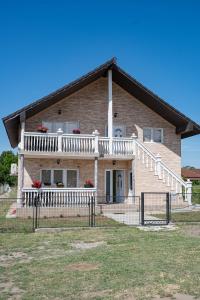 a house with a porch and a white fence at Apartman Sofija Palić in Palić