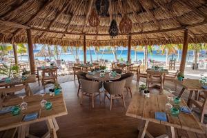 a restaurant with tables and chairs and a beach at Tropical Beach Villa with Ocean View in Blue Bay
