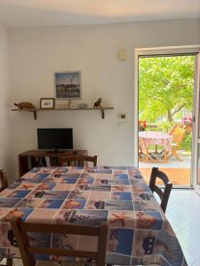 a dining room with a table and a view of a patio at Casa Mare Blu codice CITRA OO9O34 LT 1168 in Loano