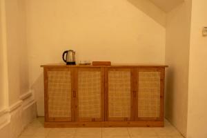 a wooden cabinet with a kettle on top of it at Warsi Bungalow in Ubud