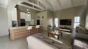 a living room with two couches and a kitchen at Ocean Whisper in Velddrif