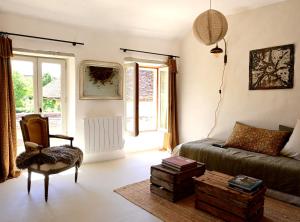 a living room with a couch and a chair at Au Canari gîte de charme in Saint-Sauveur-en-Puisaye
