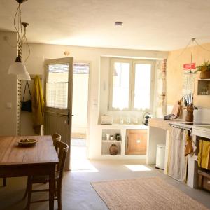 a kitchen with a table and a dining room at Au Canari gîte de charme in Saint-Sauveur-en-Puisaye