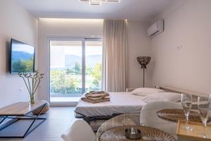 a bedroom with a bed and a large window at Enclave Luxury Apartments in Áyios Kírikos