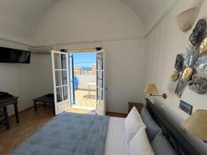 a bedroom with a bed and a sliding glass door at Leonidas Apartments in Kamari