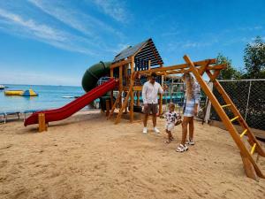 a man and a woman and a child playing on a playground at Lilly Apartments in Hurghada
