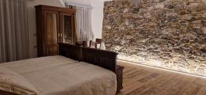 a bedroom with a bed and a stone wall at Vila Dobra in Dobravlje