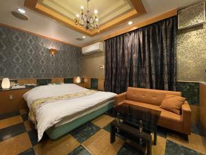 a bedroom with a bed and a couch at ホテルレイクイン in Ono
