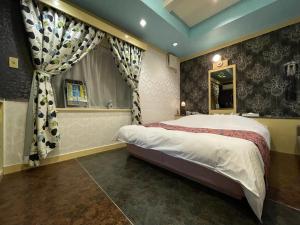 a bedroom with a large bed and a window at ホテルレイクイン in Ono