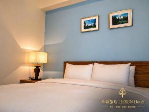 a bedroom with a bed and two pictures on the wall at He Sen B&B in Kenting +67 photos