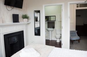 a bedroom with a bed and a fireplace and a bathroom at Ship Inn in Wylam