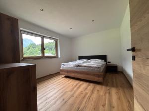 a bedroom with a bed and a window at Haischberger Apartments in Obertraun